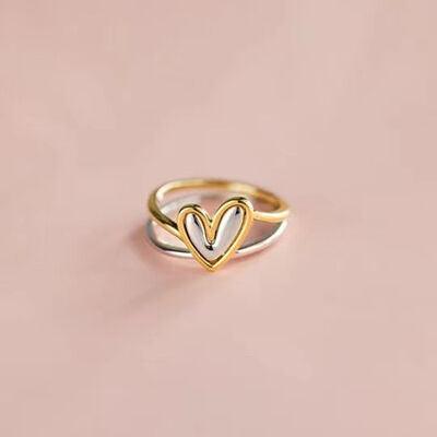 a gold ring with two hearts on it