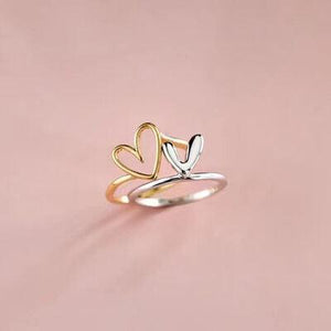 a gold and silver ring with two hearts