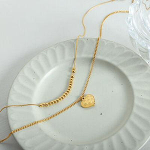 a white plate with a gold necklace on it