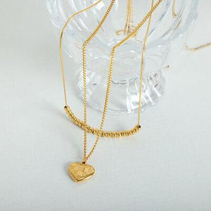 a gold necklace with a heart on it