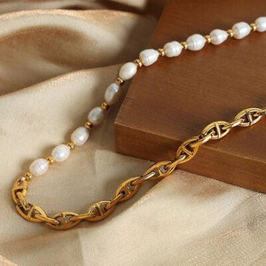 a gold chain with a white pearl beaded necklace