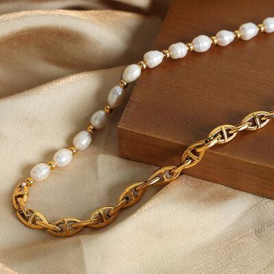 a gold chain with a white pearl beaded necklace