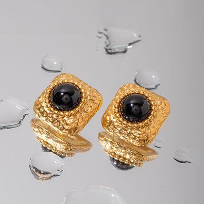 a pair of gold earrings with black stones