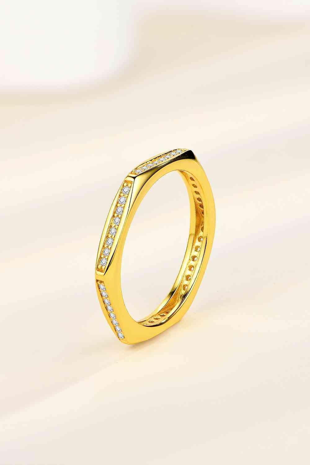a gold ring with diamonds on a white background