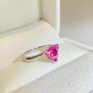 a pink heart shaped ring sitting on top of a white box