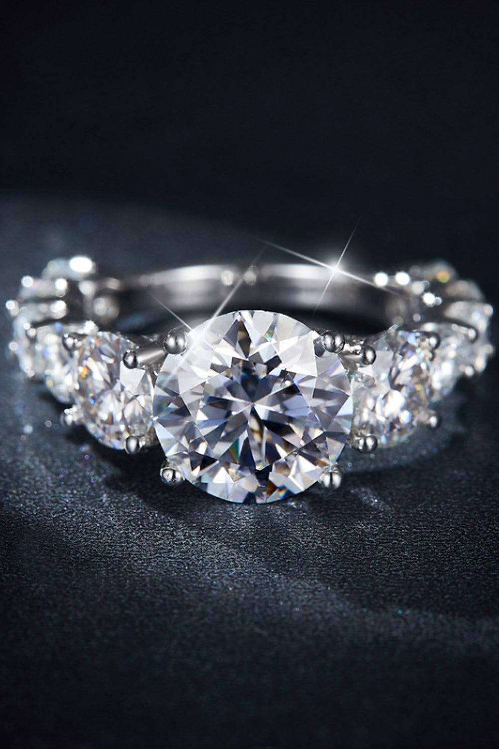 a three stone ring with a diamond center