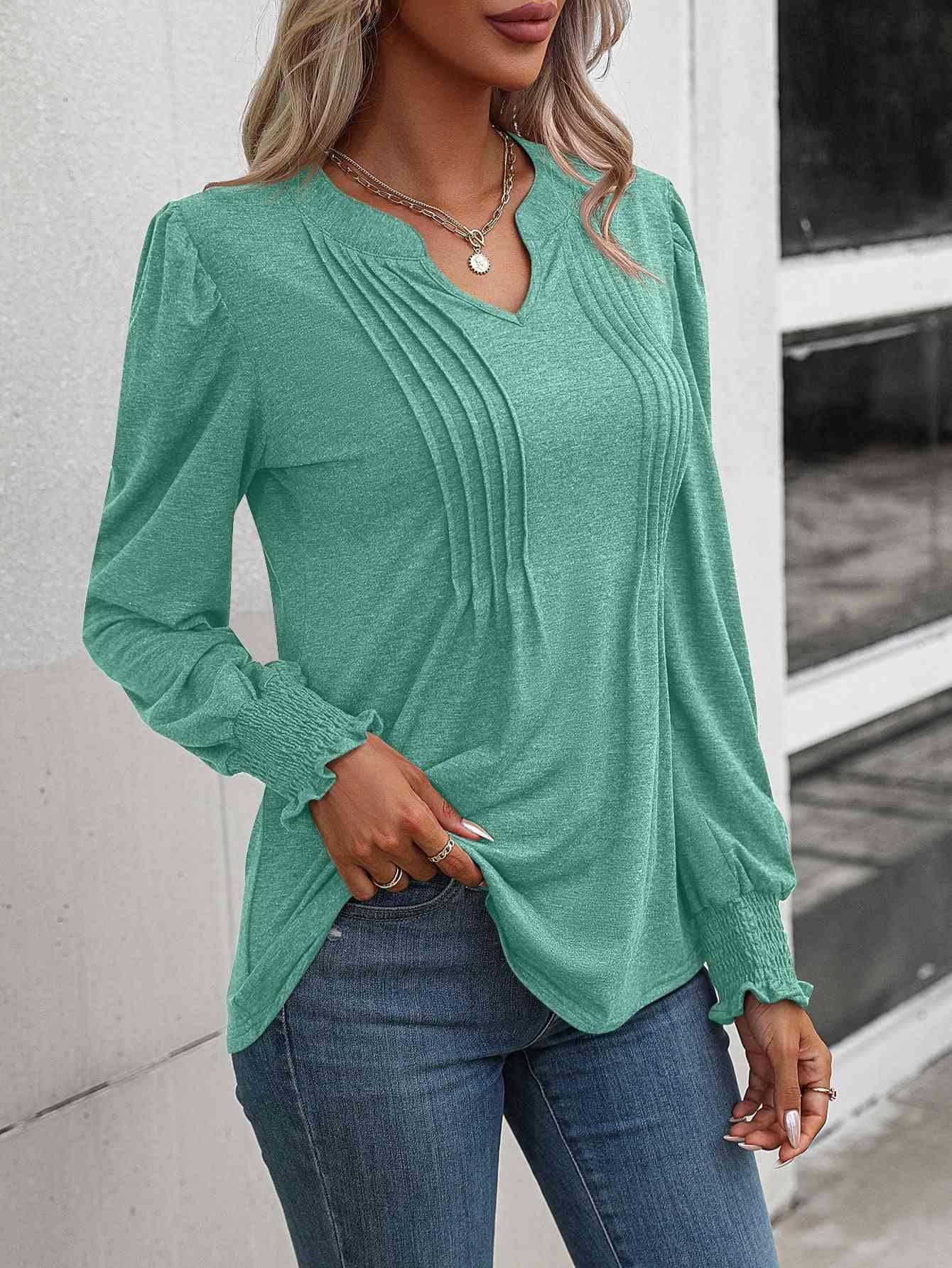 a woman wearing a green top and jeans