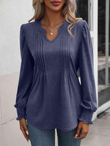 a woman wearing a blue blouse and jeans