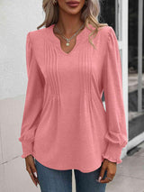 a woman wearing a pink blouse and jeans