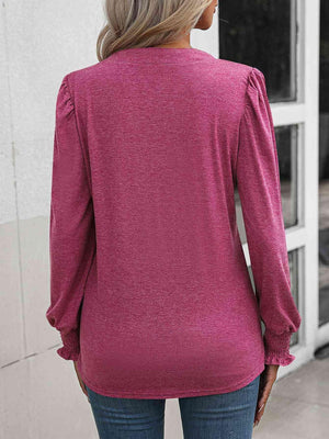 a woman wearing a pink top and jeans