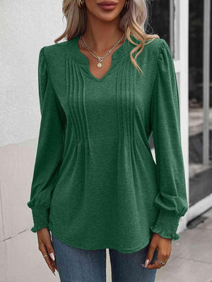 a woman wearing a green blouse and jeans