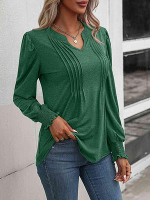 a woman wearing a green blouse and jeans