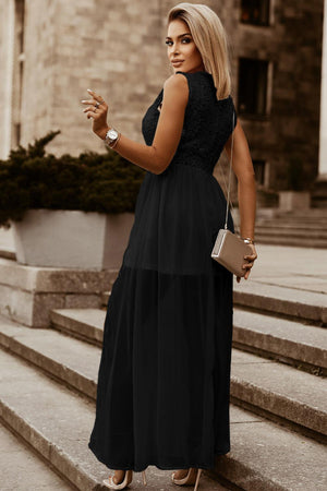 a woman in a black dress standing on some steps