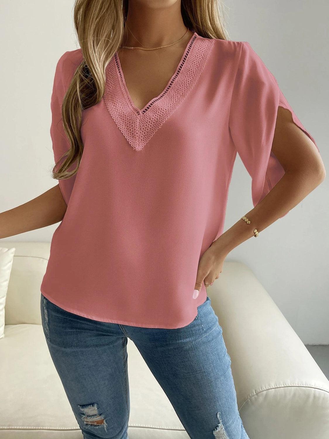 a woman wearing a pink top and ripped jeans