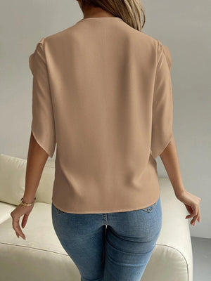 a woman wearing a tan top and jeans