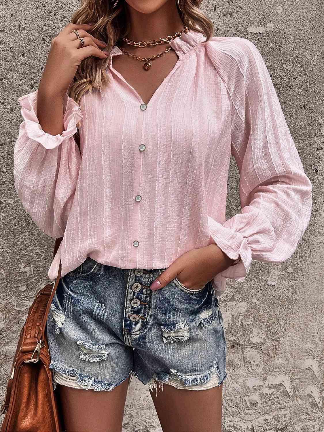 a woman wearing a pink blouse and denim shorts