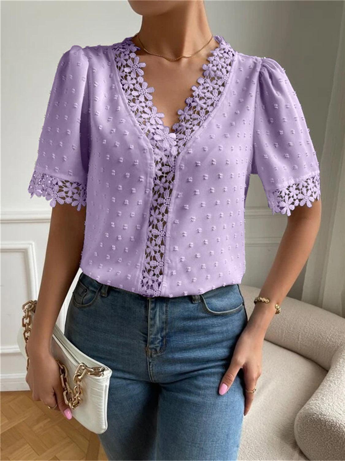 a woman wearing a purple blouse and jeans