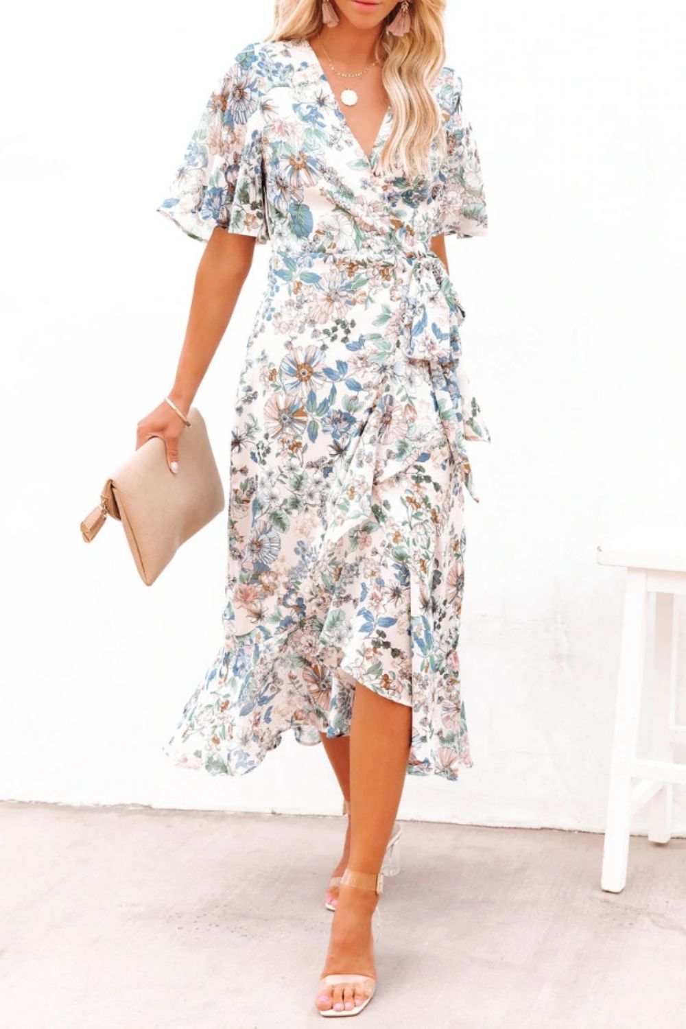 a woman wearing a white floral print dress