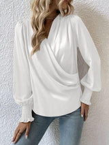 a woman wearing a white blouse and jeans