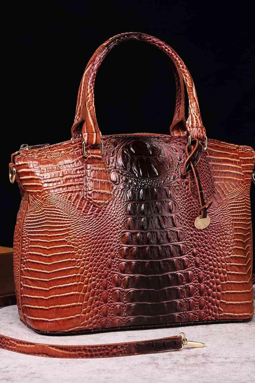 a brown alligator skin handbag with a long strap