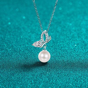 a necklace with a pearl and a butterfly on it