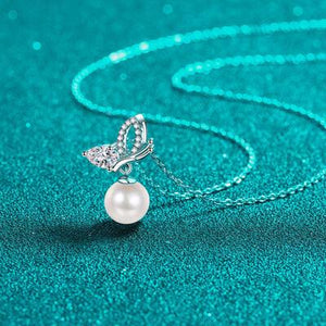 a necklace with a pearl and a butterfly on it