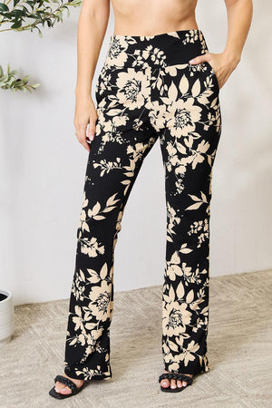 a woman wearing a pair of black and white floral pants