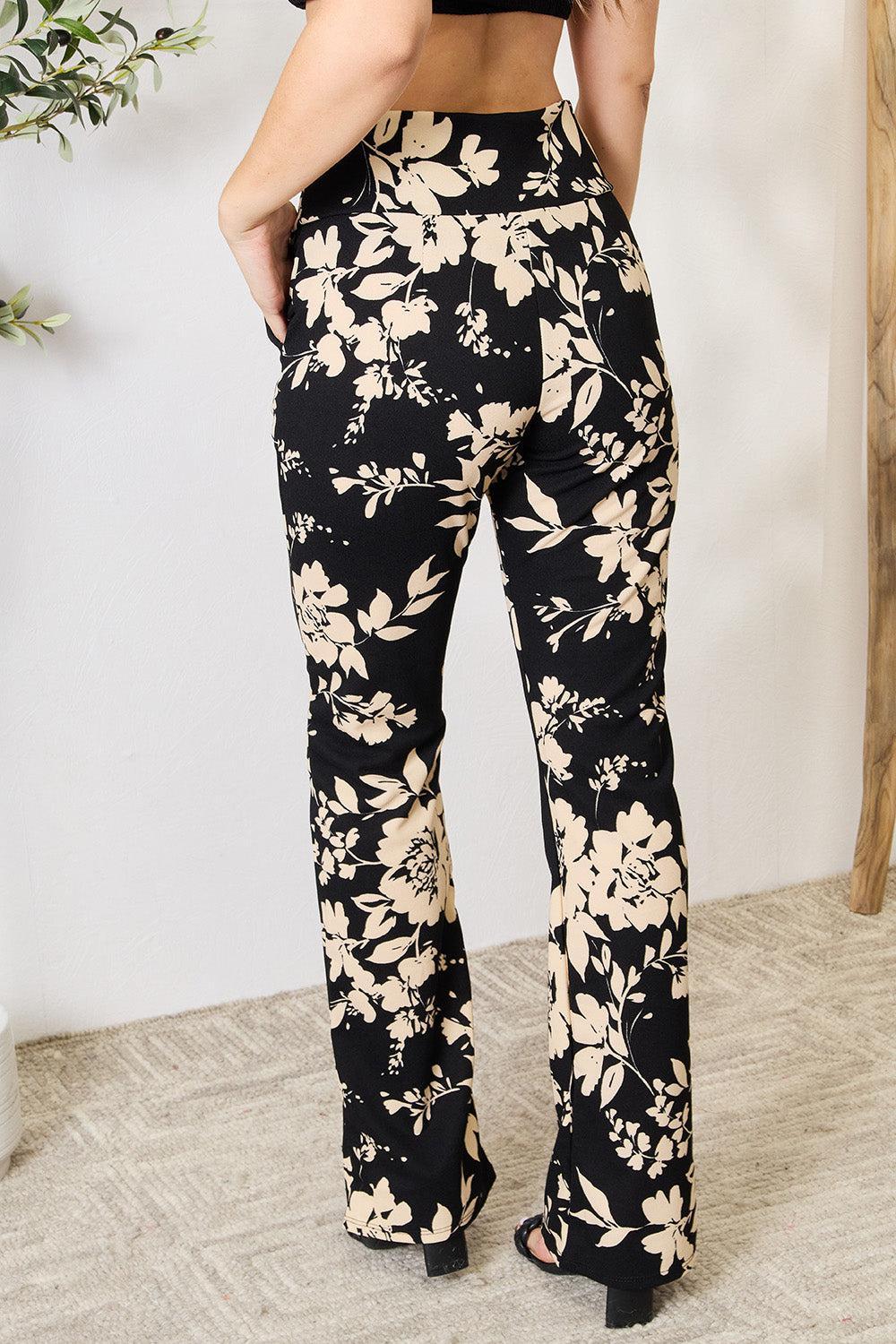 a woman in a black top and floral pants