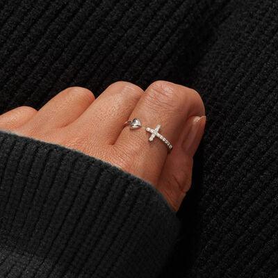 a woman's hand with a cross ring on it