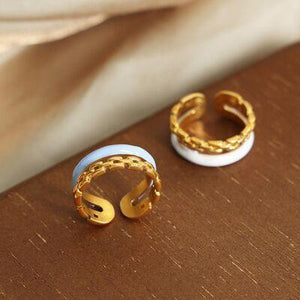 two gold and white rings sitting on top of a wooden table