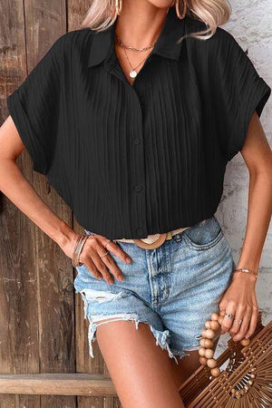 a woman wearing a black shirt and denim shorts