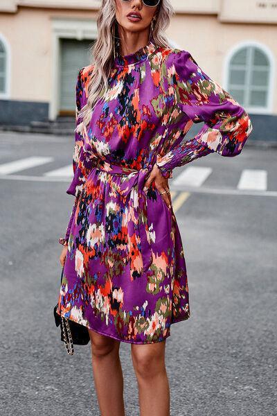 a woman wearing a purple floral print dress