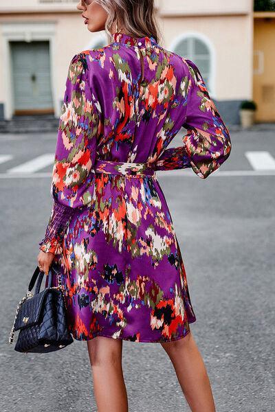 a woman in a purple floral print dress