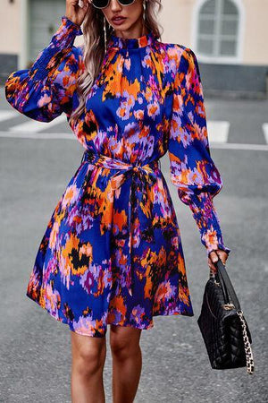 a woman in a colorful dress is talking on a cell phone