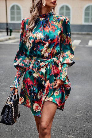 a woman walking down the street wearing a green floral dress