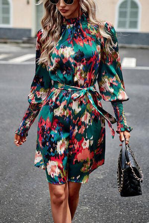 a woman walking down the street wearing a green floral dress