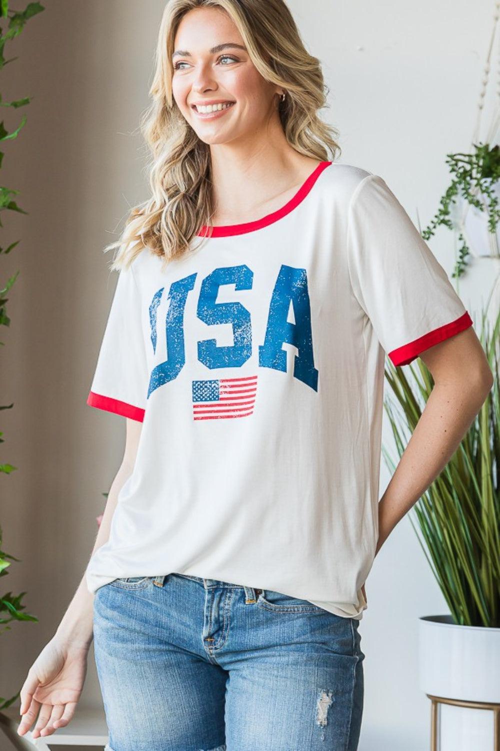 a woman wearing a usa t - shirt standing in front of a potted plant