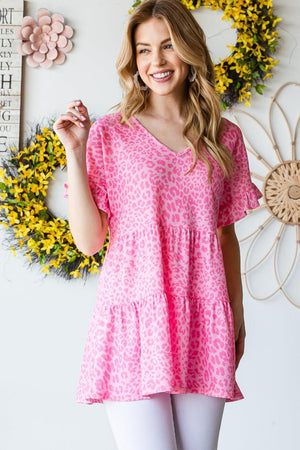 a woman standing in front of a wall with flowers