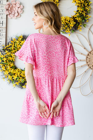 a woman standing in front of a wall with flowers