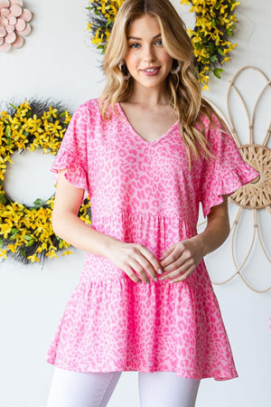 a woman standing in front of a wall with flowers