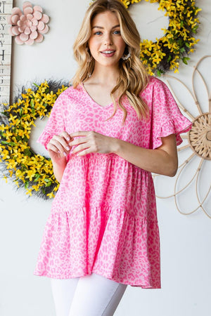 a woman standing in front of a wall with flowers