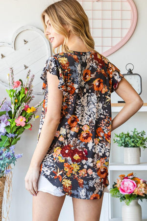 a woman standing in front of a vase of flowers