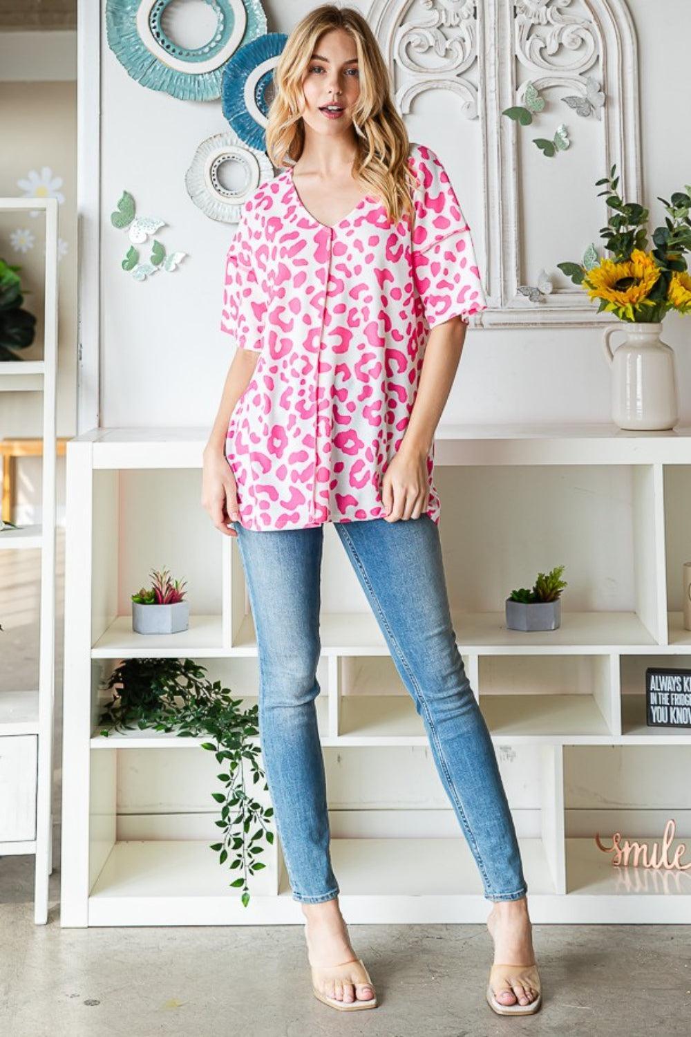 a woman standing in front of a wall with flowers