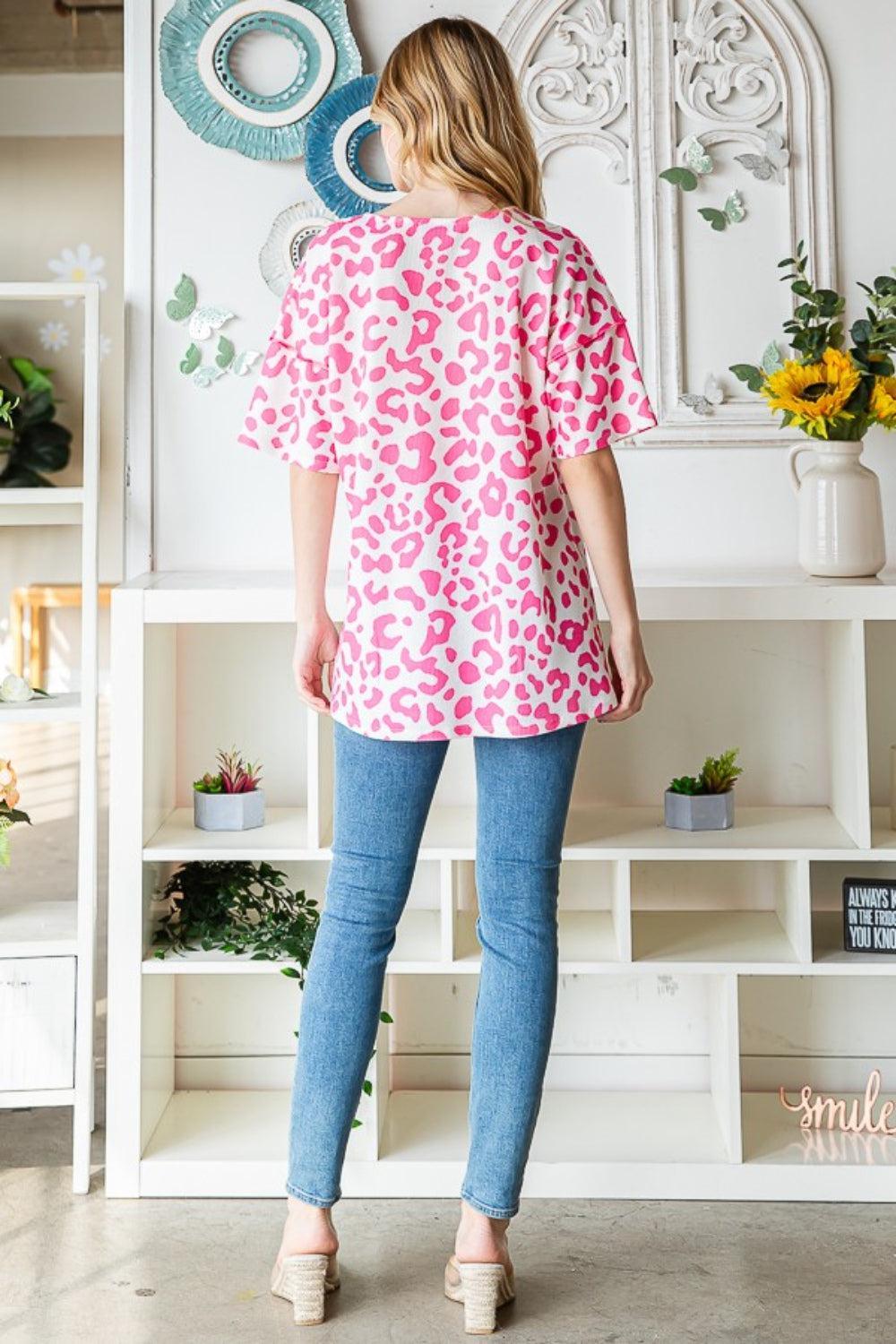 a woman standing in front of a wall with flowers