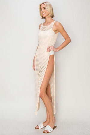 a woman wearing a white crochet dress with a slit