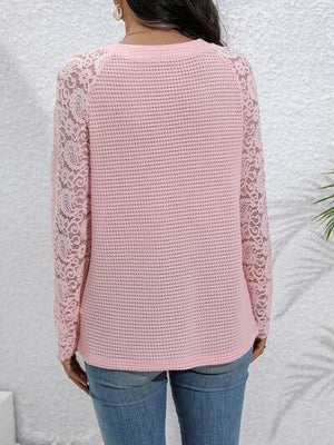 a woman wearing a pink sweater and jeans