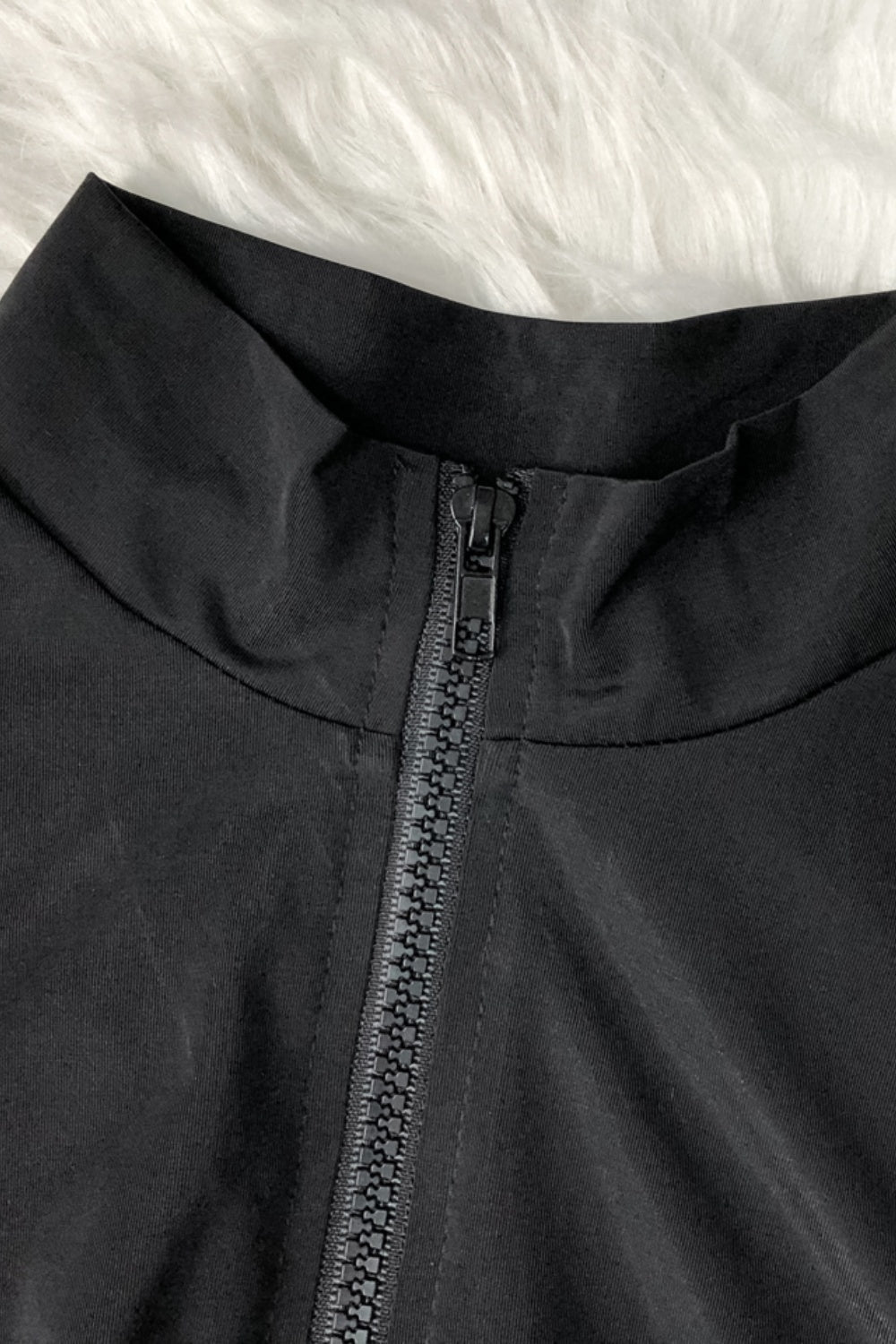 a close up of a black jacket with zippers