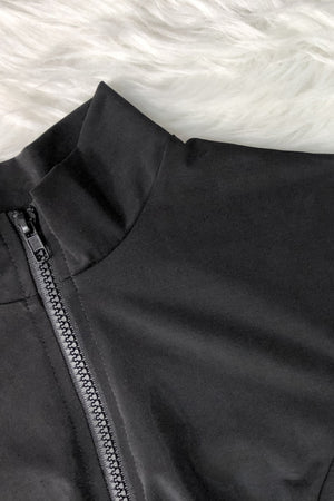a close up of a black jacket on a furry surface