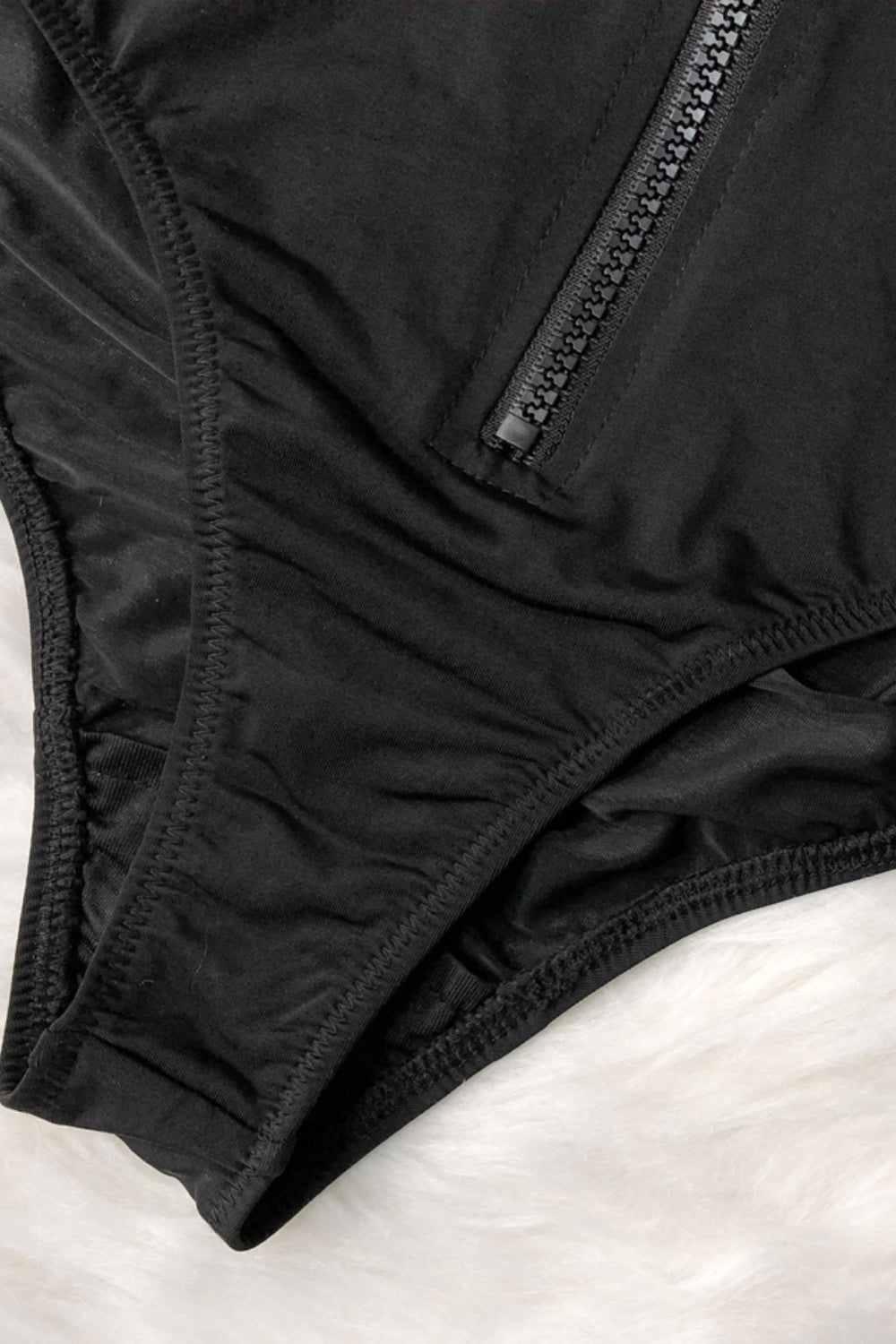 a close up of a black underwear on a white surface