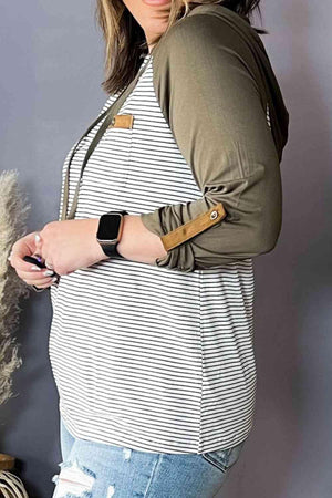 a pregnant woman wearing a striped shirt and jeans